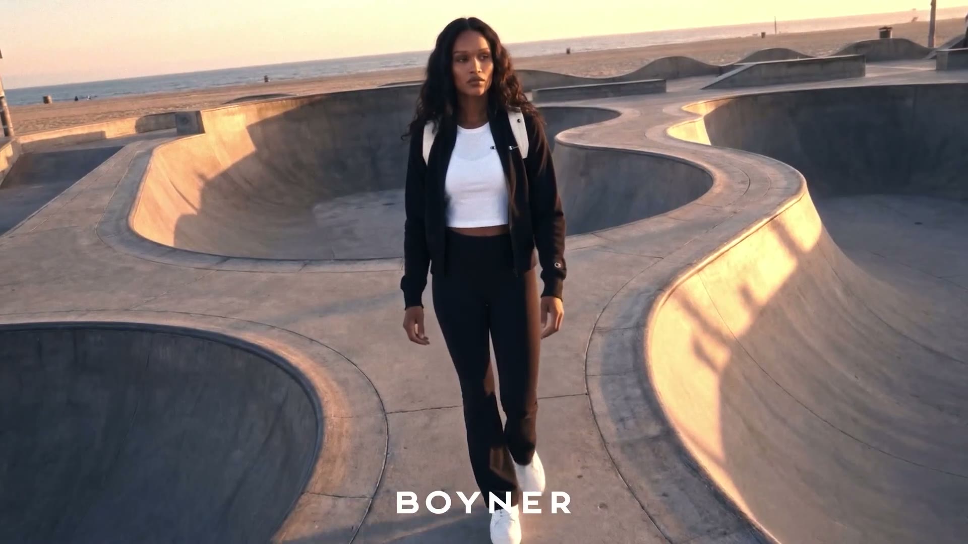 Woman walking between skate bowls — wide shot